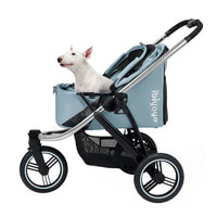 A small white dog sitting in a blue pet stroller.